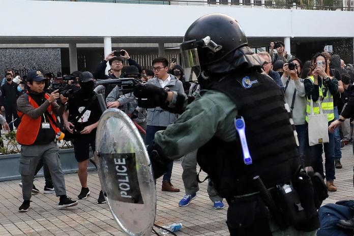 ▲香港 22 日的示威集會再度演變成警民衝突，除示威者以雜物扔警外，防暴警察亦亮槍清場。（圖／美聯社／達志影像）