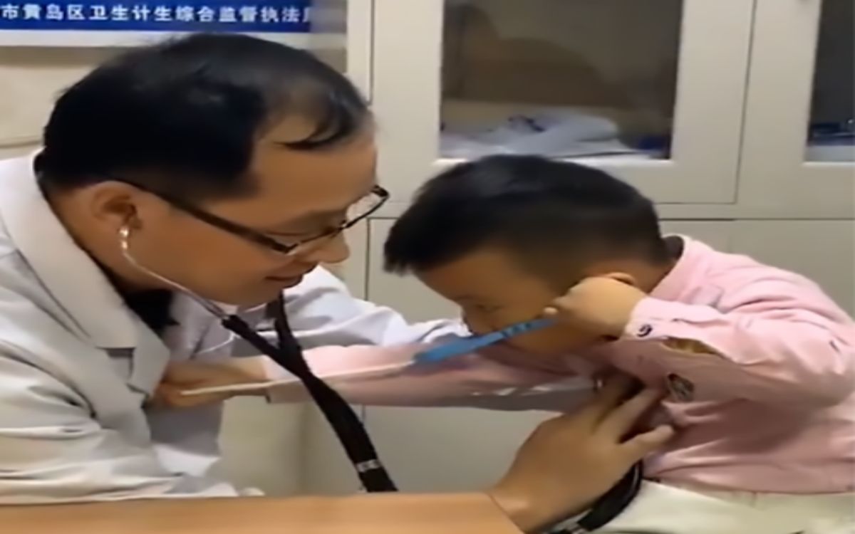 ▲小男孩認真的拿著玩具聽診器要幫醫生伯伯診治，殊不知自己中了媽媽的圈套。（圖／擷取自影片）