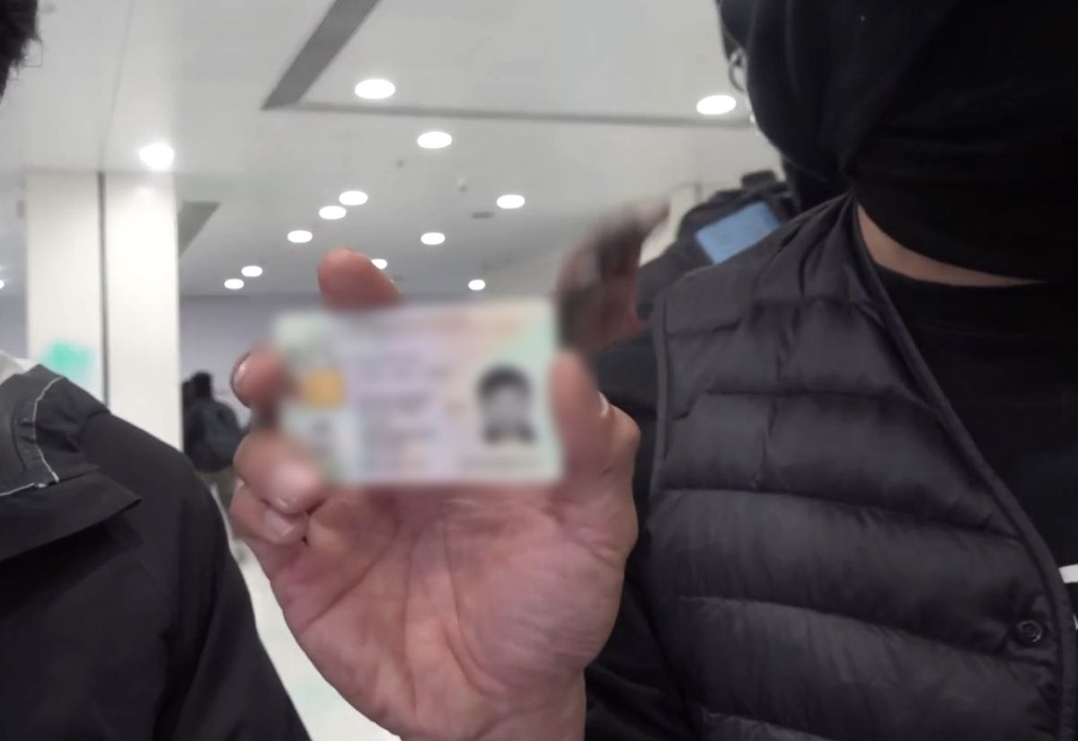 ▲警察將記者證件放置正在直播的鏡頭前。（圖／翻攝自《立場新聞》）