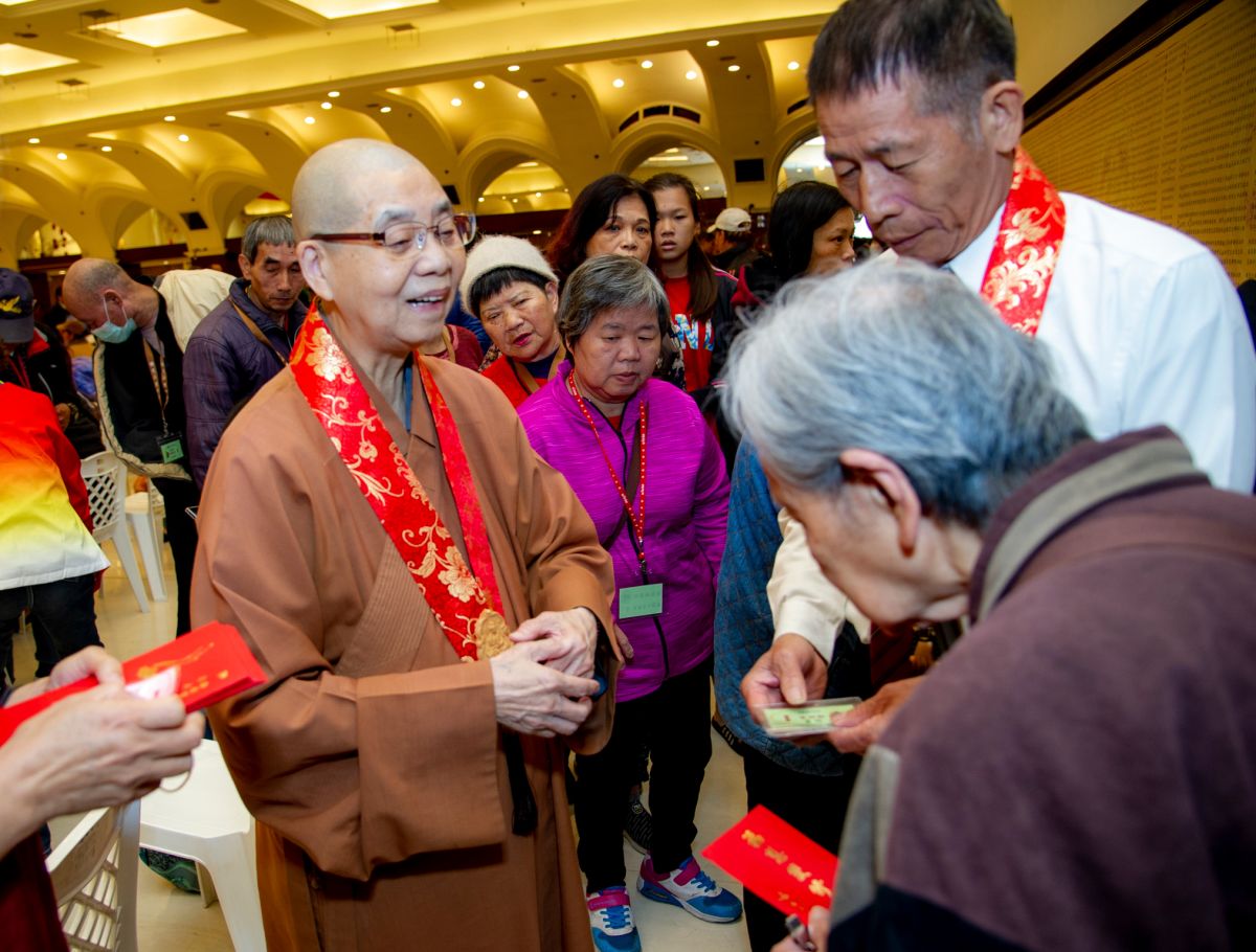 ▲佛光山慈悲社會福利基金會董事長依來法師逐一發送紅包，祝福有個美好2020年。（圖／惠中寺提供）