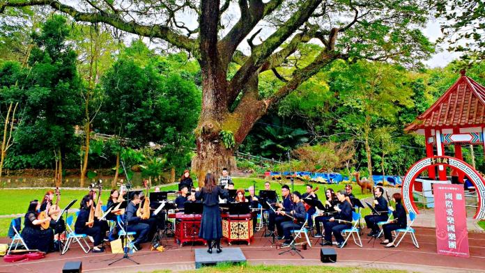 ▲國際愛樂30名演奏員於溝坪國小美麗的雨豆樹下帶來一場深具浪漫及詩意的演奏。（圖／國際愛樂國樂團提供）