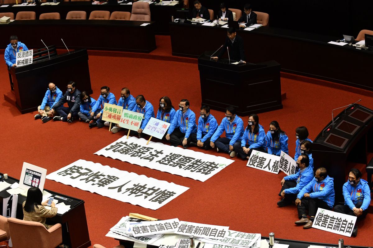 ▲國民黨團立委為了抗議民進黨倉促通過反滲透法，將抗議標語鋪在議場上，並直接席地而坐戴上黑色口罩，表達無聲抗議。（圖／記者林柏年攝, 2019.12.31）