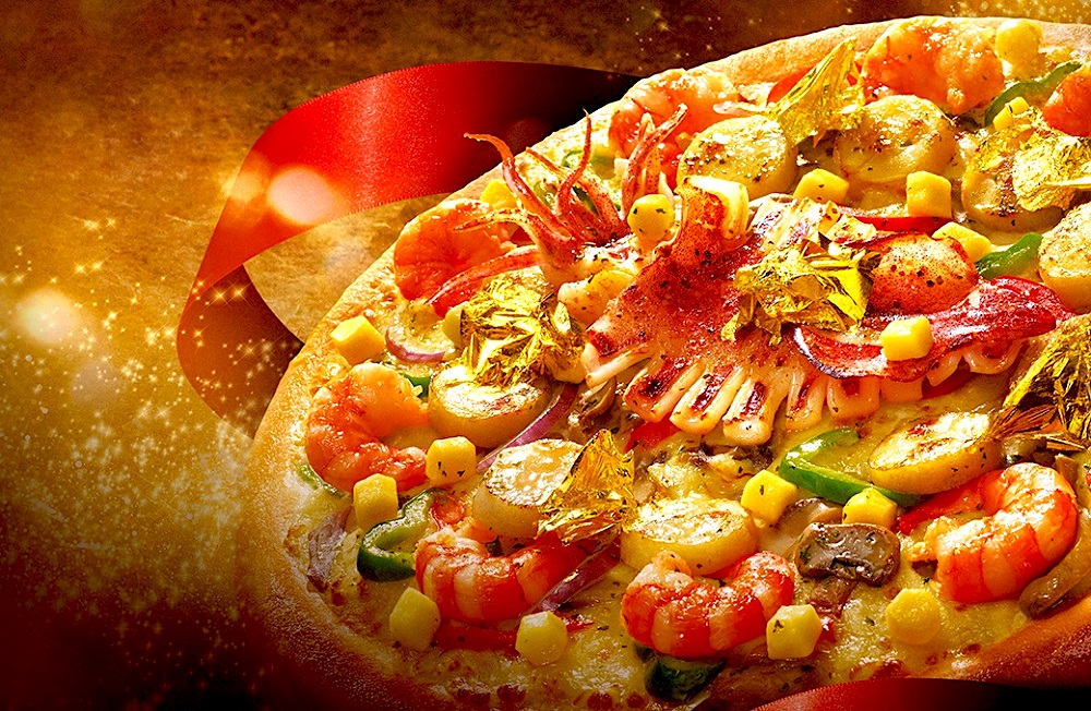 ▲知名連鎖比薩業者因應春節，推出主打豪華高檔的年節限定比薩，除了使用北海道起司塊，更在比薩上撒下大塊金箔、干貝。（圖／業者提供）