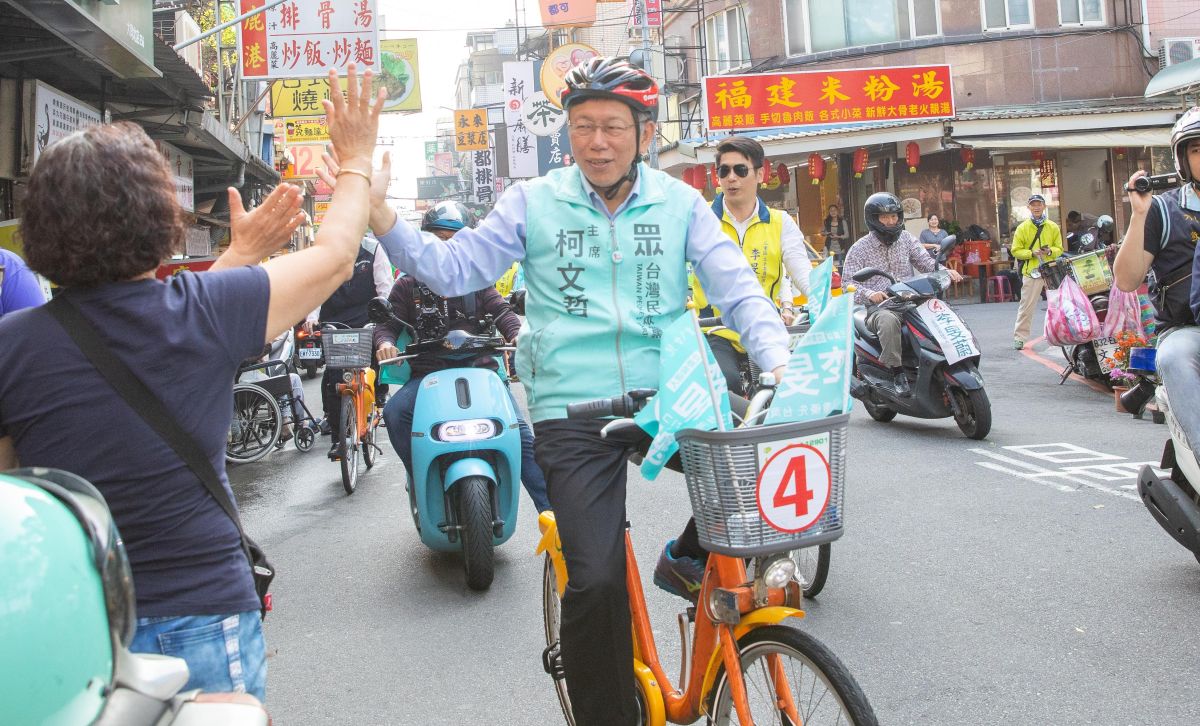 ▲身兼台灣民眾黨主席的台北市長柯文哲，騎腳踏車為民眾黨三重立委候選人李旻蔚掃街拜票。（圖／台灣民眾黨提供）