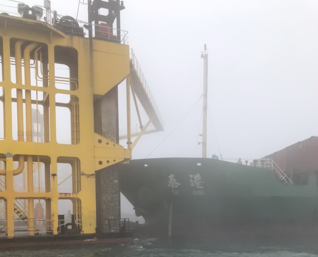 ▲中國籍泰港號散裝貨輪因起霧能見度不佳，不慎撞擊中信8號船塢，致平台凹陷破洞，而泰港號貨輪船頭靠水下左右船殼破洞毀損。(圖／記者黃守作攝，2020.01.06)