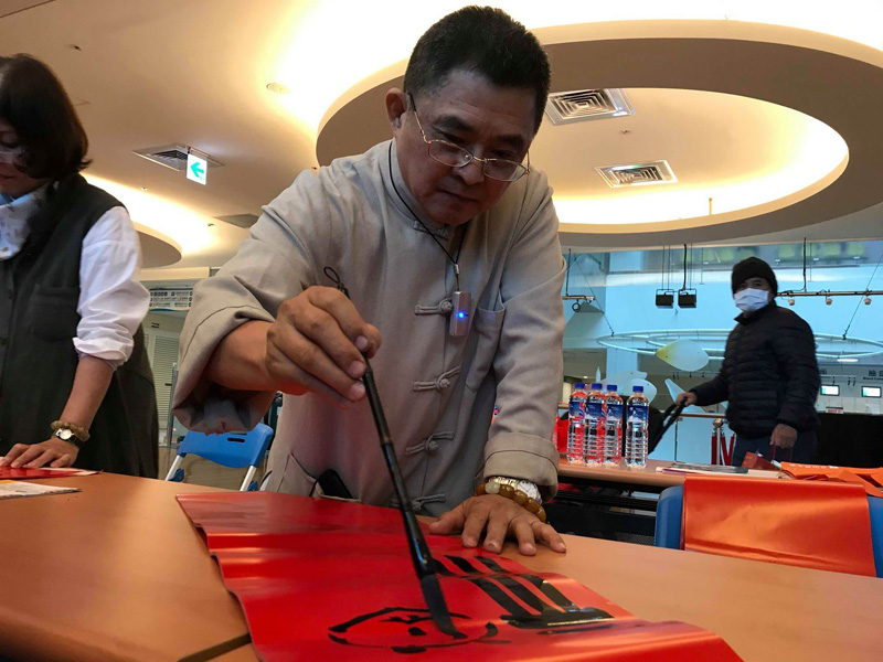 ▲書法名家吳大仁在陽大醫院現場揮毫寫春聯，提供民眾免費索取。（圖／陽明大學附設醫院提供)