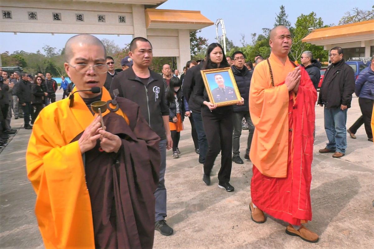 ▲洪鴻鈞大女兒洪孟庭手捧父親遺像步，在軍方車隊的護送下前往金門殯儀舉行公祭。（圖／蔡若喬攝, 2020.01.16）