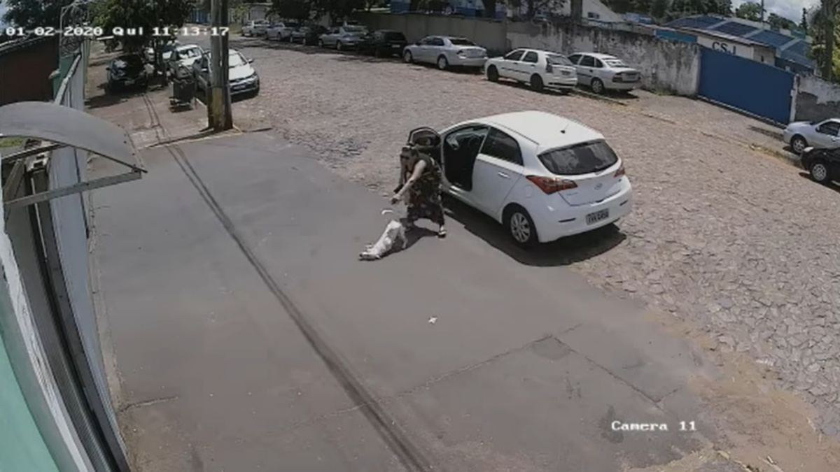 女子狠狠將白狗摔在地上，便關上車門駛離。（圖／Facebook@Anderson Ribeiro FanPage）