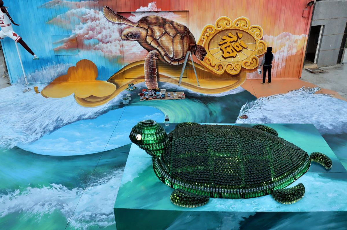 ▲澎湖石泉朱王廟請來美女彩繪師許梅妤現場畫出3D海底世界，搭配2000多瓶海尼根啤酒堆砌的創意水晶龜，成為金鼠年元宵慶典最有特色的作品。（圖／記者張塵攝，2020.02.01）
