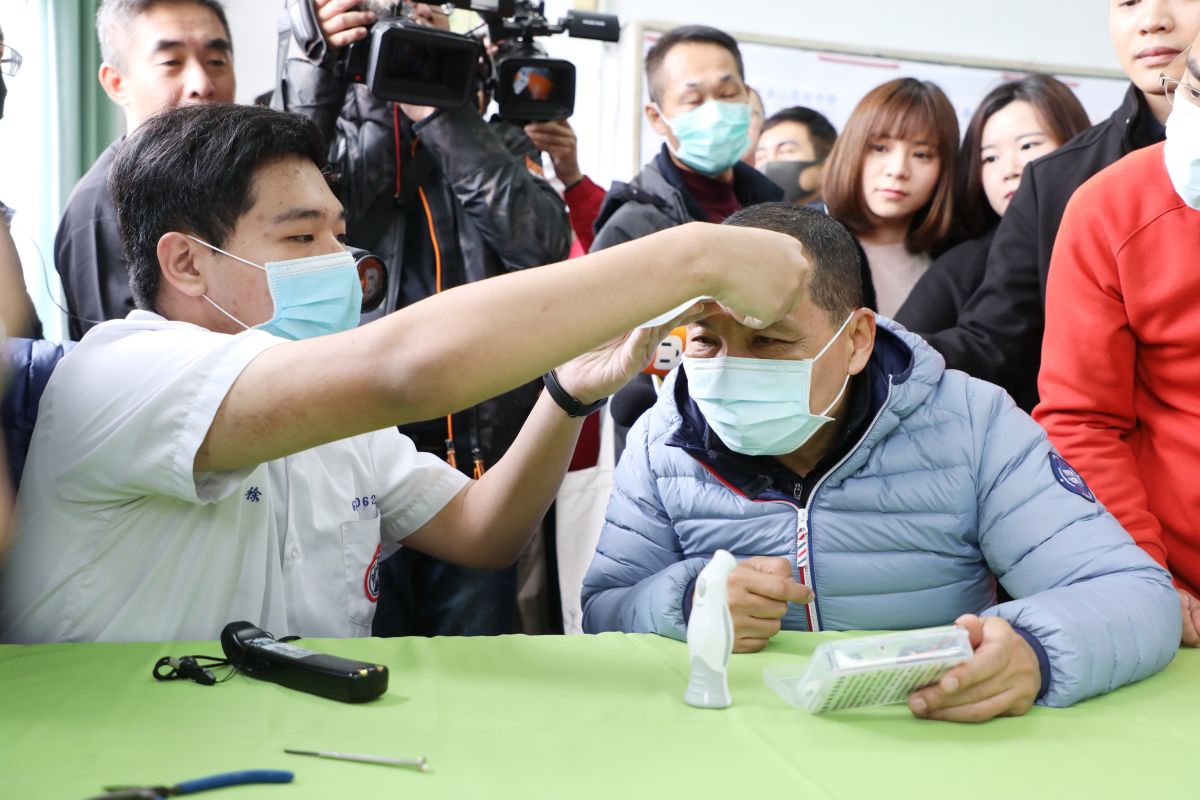 ▲新北市泰山高中電子科師生利用電板燒錄、焊接電路、程式設計等課程，自製出校園版額溫槍，侯友宜實測溫差。（圖／新北市新聞局提供）