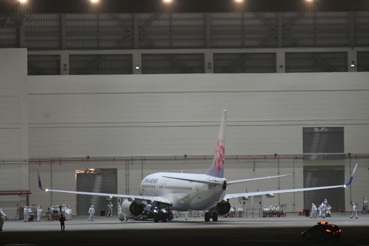 ▲飛機落地後，依循上次武漢包機地毯模式，轉往維修機棚進行旅客下機檢疫通關作業。（圖/記者林調遜攝影）