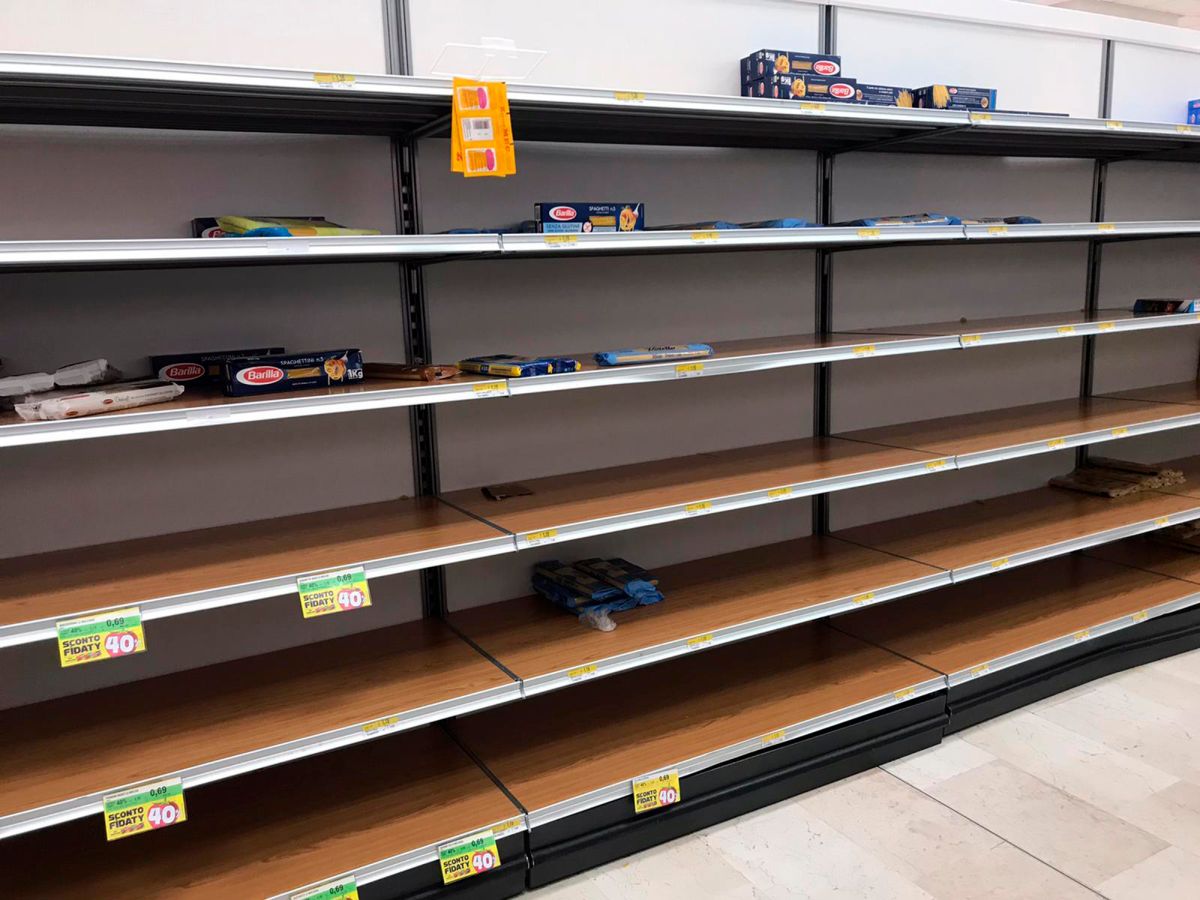 Empty shelves are seen in a supermarket in Rozzano, near Milan, Sunday, Feb. 23, 2020, as fears rapidly spread in Northern Italy with a sudden surge of COVID-19 cases. A dozen Italian towns saw daily life disrupted after the deaths of two people infected with the virus from China and a pair of case clusters without direct links to the outbreak abroad. A rapid spike in infections prompted authorities in the northern Lombardy and Veneto regions to close schools, businesses and restaurants and to cancel sporting events and Masses. (AP Photo/Antonio Calanni)