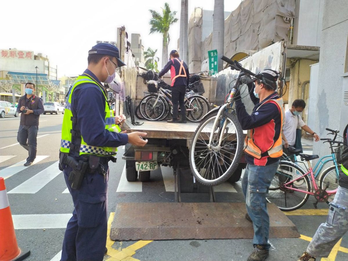 ▲警方先在腳踏車坐墊貼上編號，再由清潔隊人員一輛一輛搬上回收車，此次清除了上百輛違停腳踏車。（圖／記者葉靜美攝，2020.03.09）