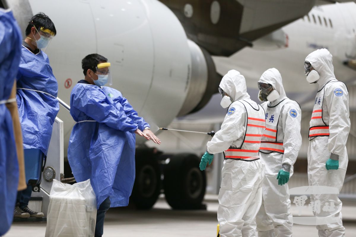 ▲國軍化學兵部隊為返國的乘客們進行第一道消毒作業。（圖／軍聞社提供, 2020.3.11）