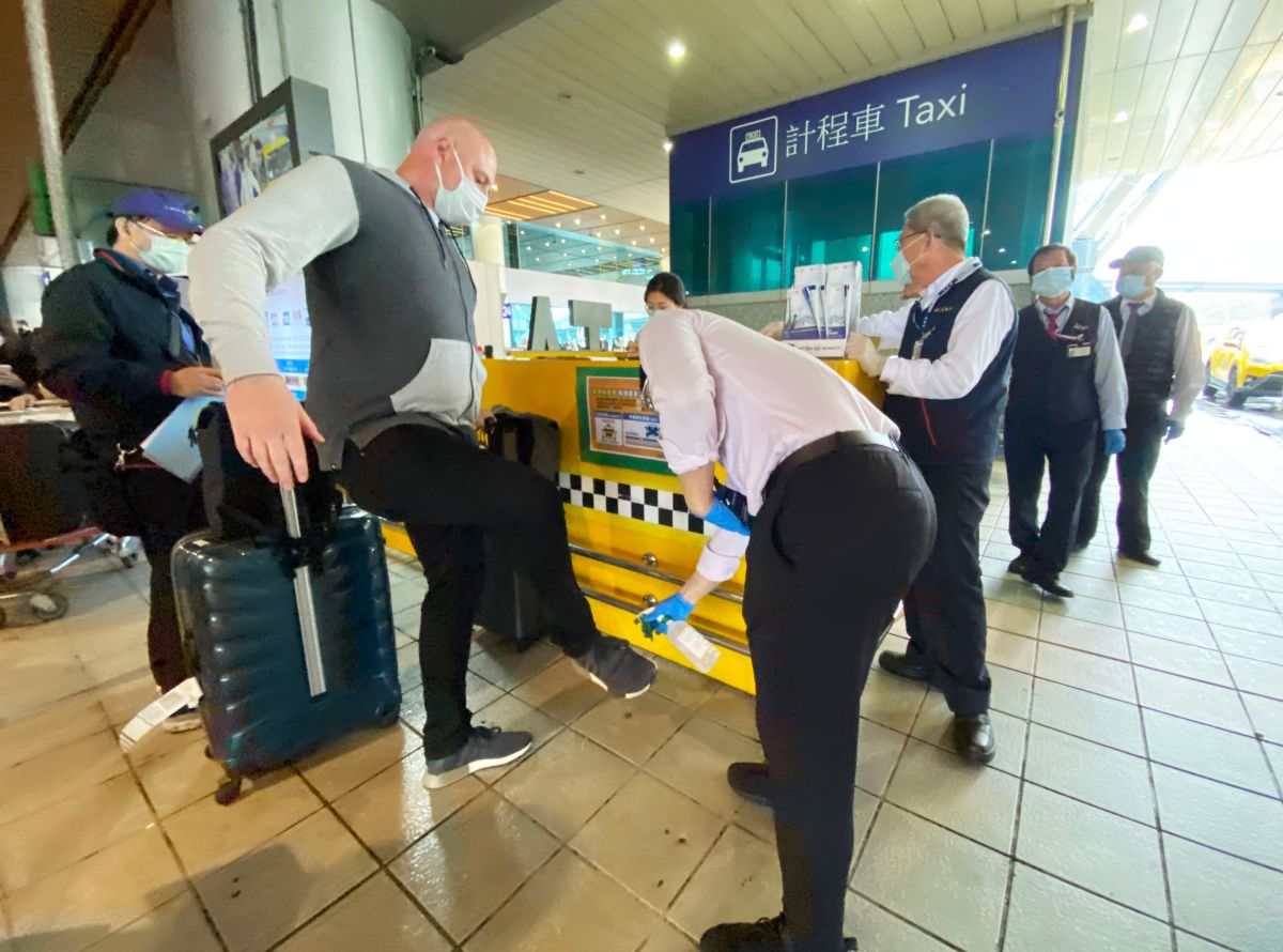 ▲台灣今天實施邊境管制首日，來台旅客按規定均需搭乘「防疫計程車」，圖為一名外籍旅客上車前接受全身消毒情形。（圖／記者李春台攝, 2020.03.19）