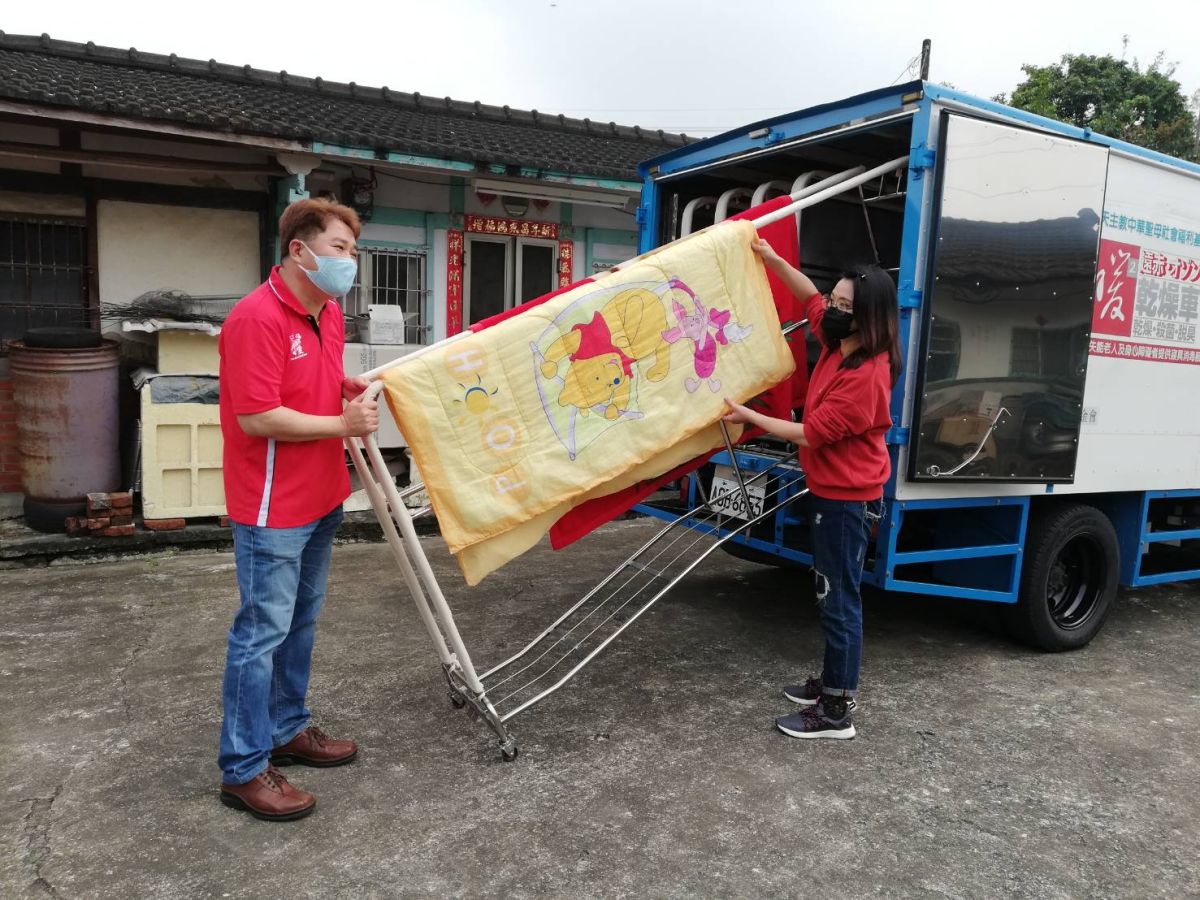 ▲海芬將阿公阿嬤的被子、枕頭等，一桿一桿掛上「加熱乾燥車」。（圖/記者邱嘉琪攝，2020.03.24）