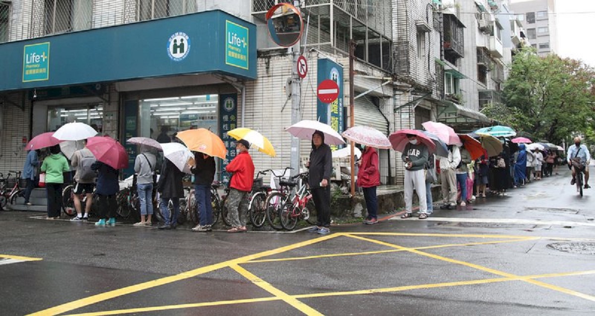 武漢肺炎疫情未見緩解，中央流行疫情指揮中心28日宣布再增16例確診個案，全台累計病例達283例。午後許多民眾雨中撐傘在藥局外排隊，等候購買口罩。中央社記者張新偉攝109年3月28日

