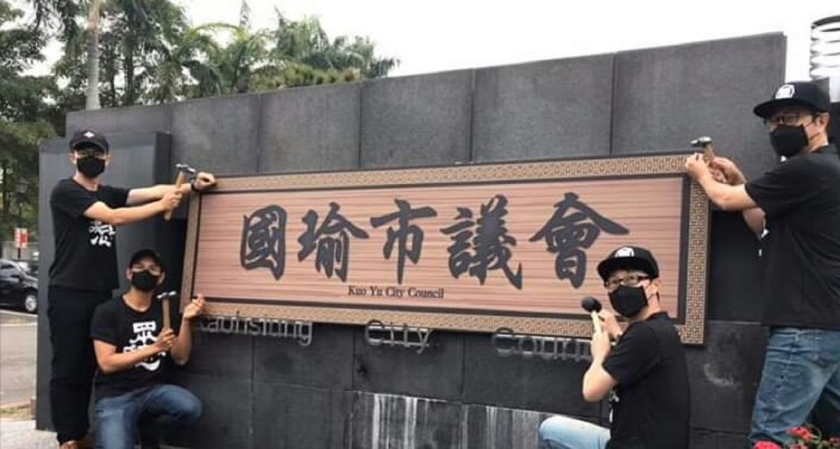 ▲罷韓團體今天上午到高雄市議會抗議，拿出「國瑜市議會」牌子要釘在議會牆面上，質疑高雄市長韓國瑜操控議會規避總質。(圖／截自Wecare高雄臉書)