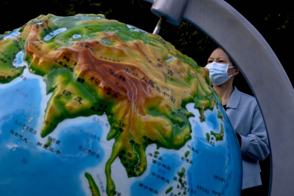 ▲地球儀和戴口罩的人。（圖／美聯社／達志影像）