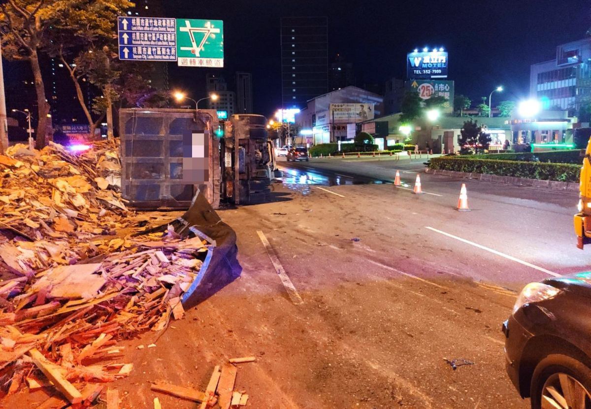 ▲聯結車行經南崁新南路附近，一輛聯結車因為擦撞安全島側翻，車上所載運的木料散落一地。（圖／蘆竹分局提供　）