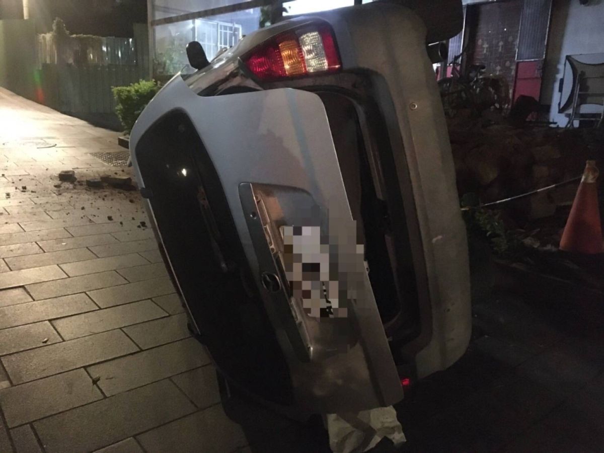 ▲銀白色自小客車撞民宅後翻覆。(圖／金城分局提供）