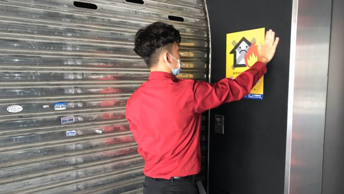 ▲消防局安檢隊員在場所外張貼消防安全不合格告示。（圖／台北市政府消防局提供）