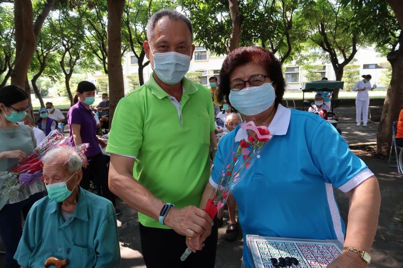 ▲家主任王正在祝福影片播放後,一一為現場的母親們獻上一朵康乃馨,當然也包含了辛苦防疫的工作同仁。(圖/記者陳雅芳攝,2020.05.07)