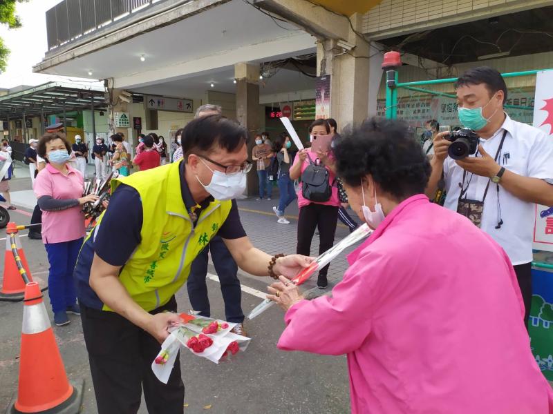 ▲收到林世賢遞來的美麗康乃馨花束，婦人笑容燦爛，火車站出口，充滿溫馨。（圖／記者葉靜美攝，2020.05.08）