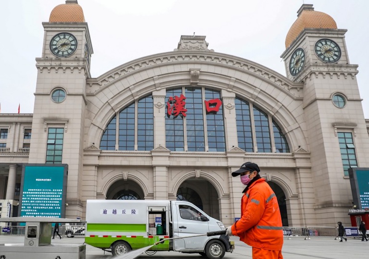 ▲疫情期間在漢口車站前消毒的人員。（圖／翻攝自《南華早報》）