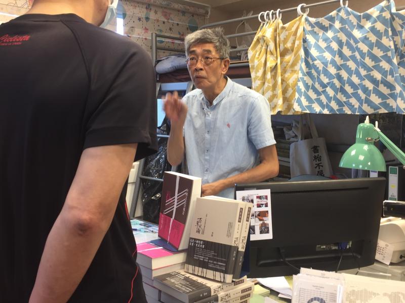 ▲林榮基與客人討論書本內容。(圖/記者黃仁杰攝)