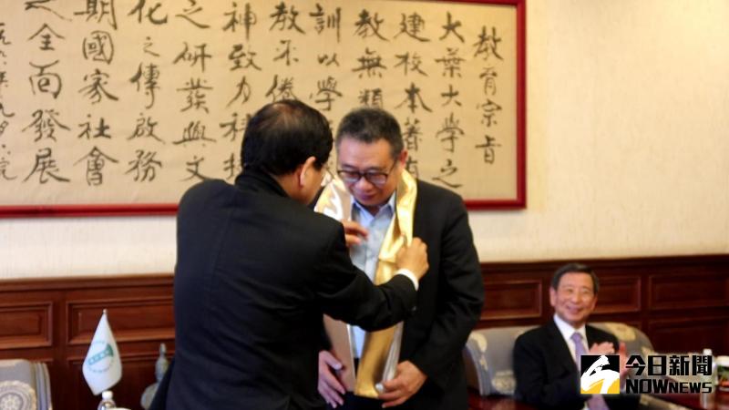 ▲萬泰集團董事長張銘烈為校長梁卓中戴上黃金哈達。(圖/記者陳雅芳攝,2020.05.26)