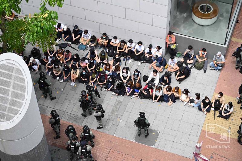▲數十位香港市民被警方要求坐在地上接受盤查。（圖／翻攝自《立場新聞》）