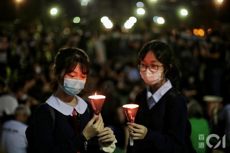 ▲香港教育局局長在電台節目上鼓勵學生通報污辱國歌者。圖為 6/4 香港中學生手持燭光參加維園集會。（圖／翻攝自《香港 01 》）