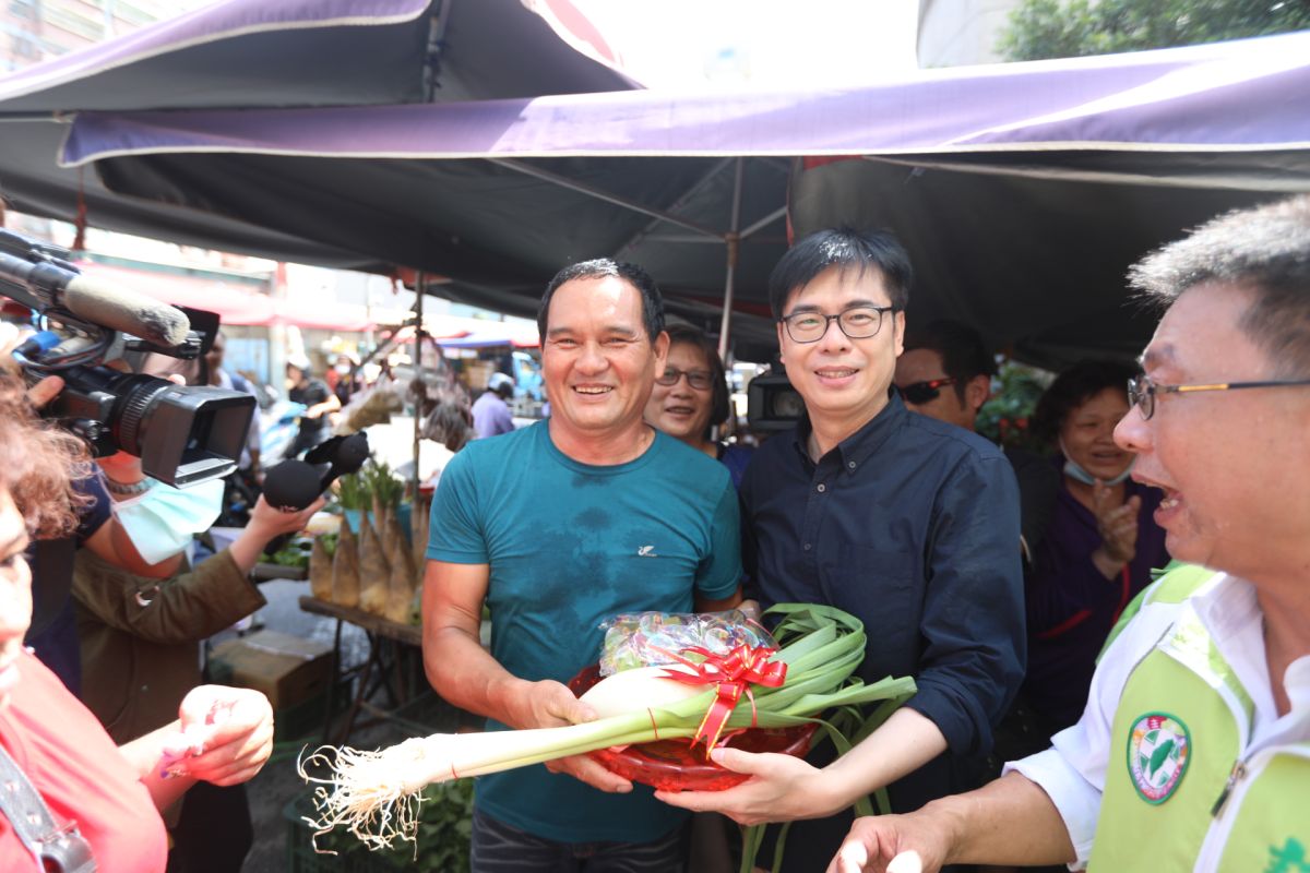 ▲民進黨高雄市長補選參選人陳其邁今天上午6時就到十全果菜市場、肉豆公市場，熱情的攤商送上蘿蔔、蒜苗象徵「好彩頭」「凍蒜」。(圖／記者郭凱杰翻攝，2020.06.19)