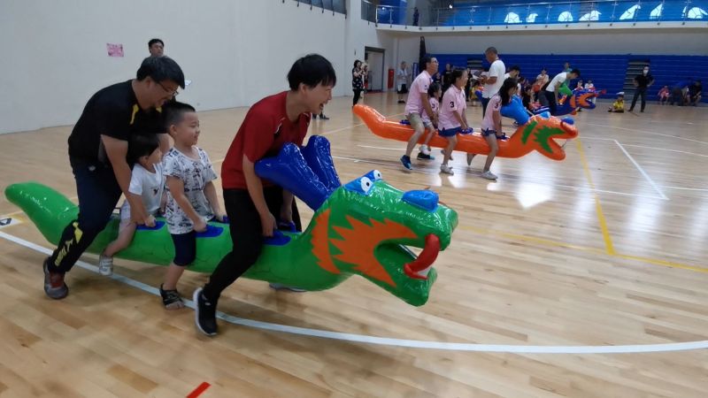 ▲家長幾乎是抬著充氣龍舟上小朋友在奔跑,來回一趟下都汗流浹背,氣喘吁吁。(圖/記者蔡若喬攝)