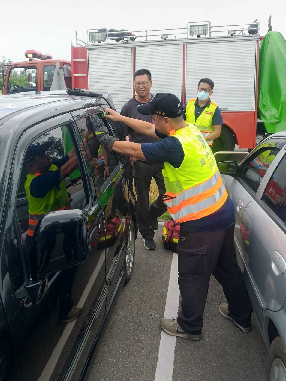 ▲小孩受困車內，金城消防分隊以玻璃擊破器破窗救人。(圖/金城消防分隊提供)