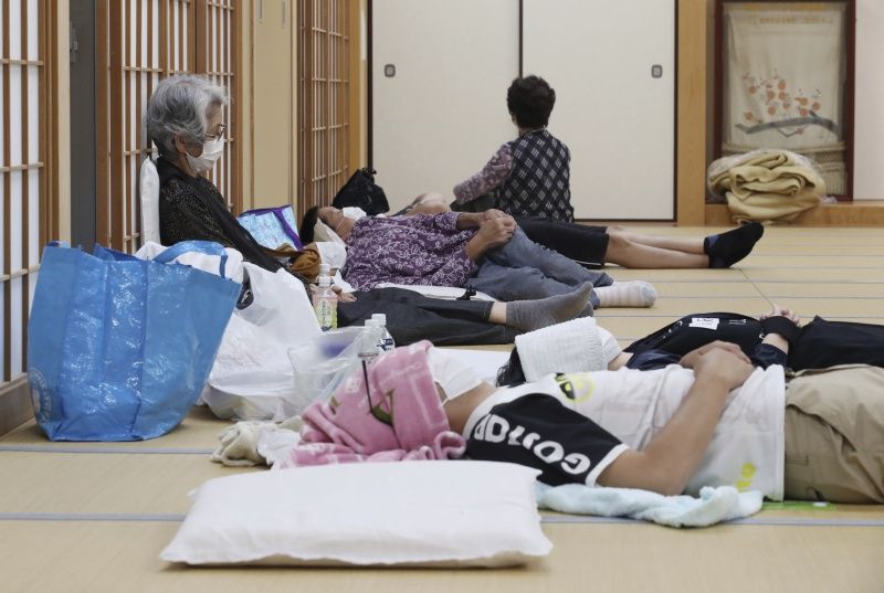 ▲突如其來的暴雨,讓許多民眾倉皇逃生,去臨時收容所暫避。(圖/美聯社/達志影像)