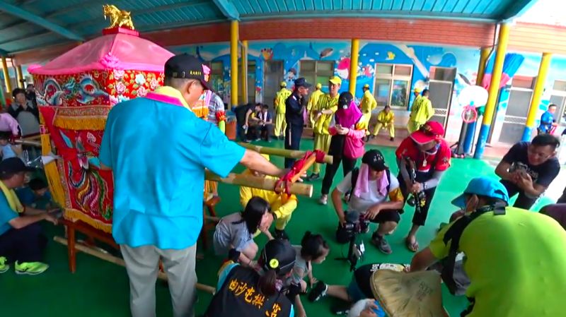 ▲媽祖鑾轎進到幼兒園讓孩子們鑽轎底賜福。(圖/翻攝自白沙屯媽祖網路電視台)