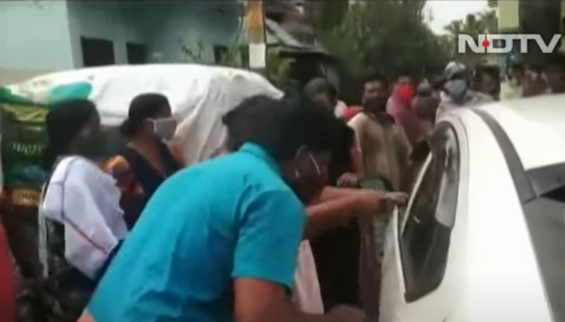 ▲印度喀拉拉邦一處村落,近日發生村民包圍醫療團隊車輛、意圖以咳嗽、吐沫等方式感染防疫人員的離譜事件。(圖/擷取自 NDTV 影片片段)