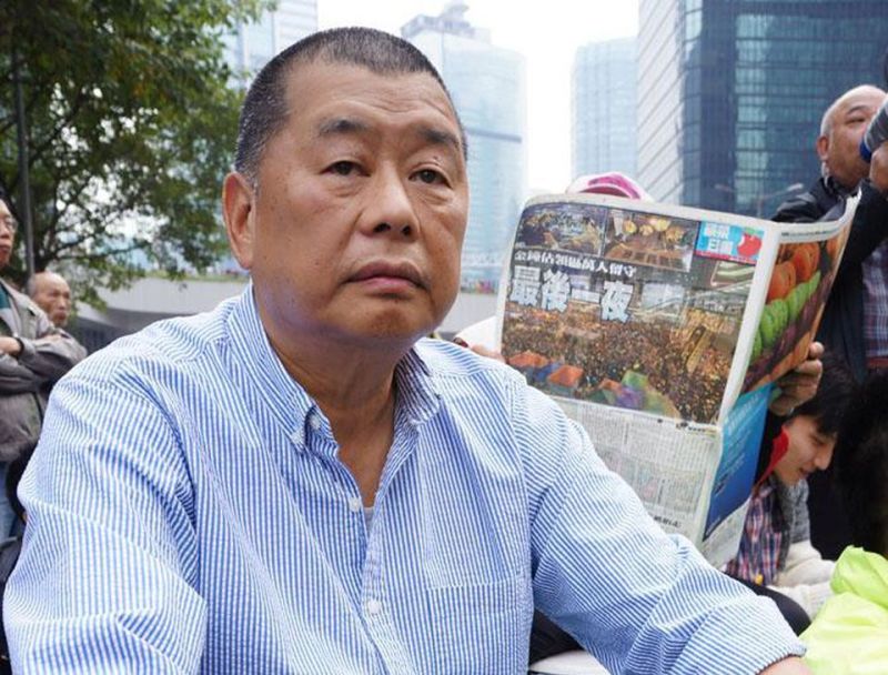 ▲黎智英參與抗議活動時,後面正好有示威者正在閱讀《蘋果日報》。(圖/翻攝自