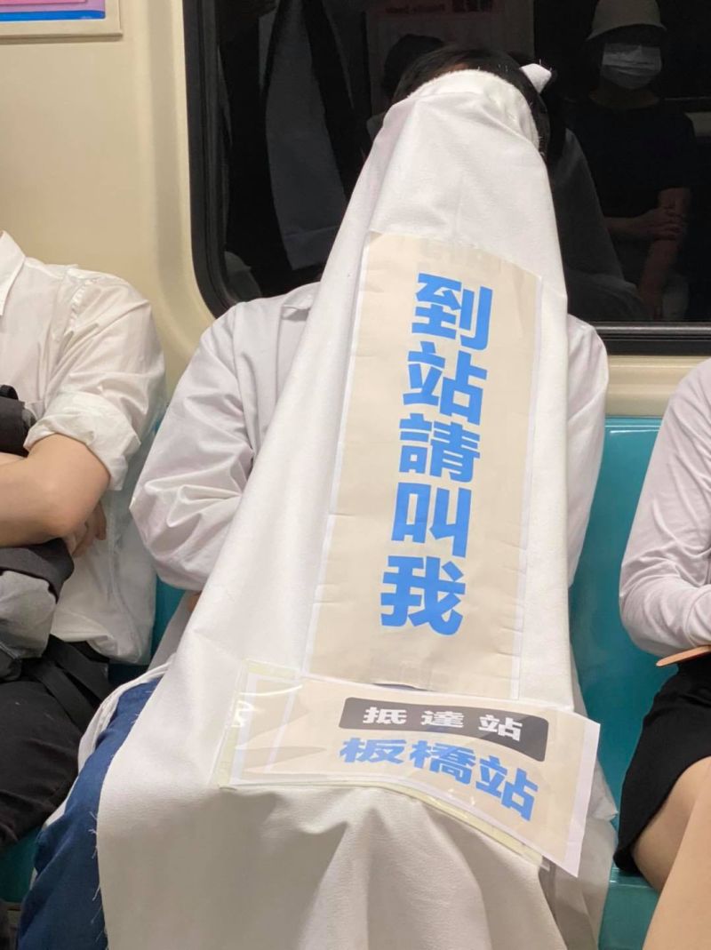 ▲有乘客搭捷運怕睡過頭,在身上蓋醒目布條求提醒,引發熱議。(圖/翻攝自台灣迷因