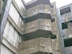 ▲新北市新莊區新北大道7段某社區正後方有一棟20年前施工未完的五層樓公寓廢墟，如今地下室已成池塘，形成治安死角。（圖／新北市工務局提供）