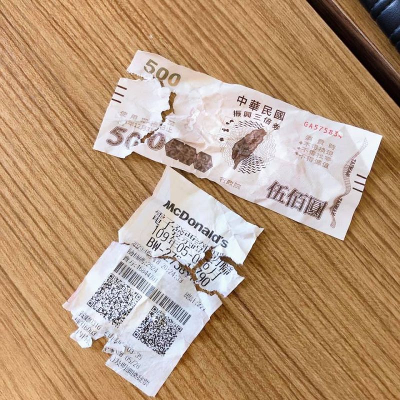 ▲一張面額500元的三倍券和中獎發票,因倍女嬰勿食,而呈現破爛的狀況。(圖/翻攝爆怨公社臉書)