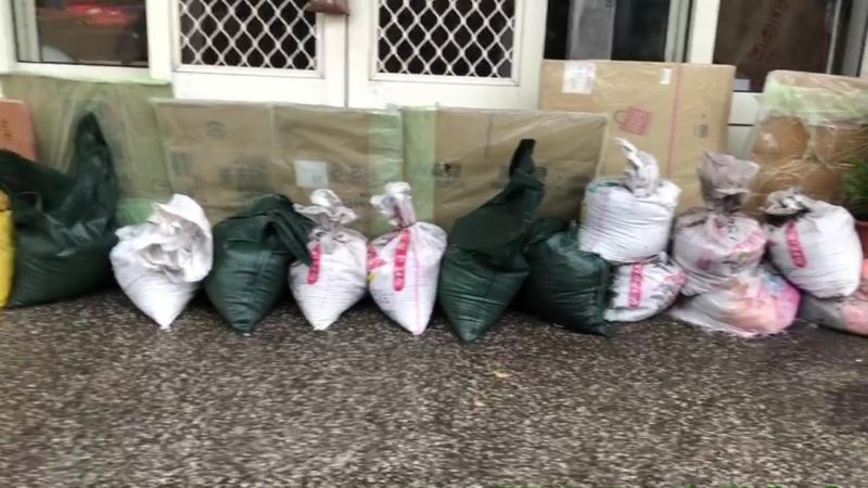 ▲因為大雨來不及宣洩,路口積水超過腳踝,一度達到30公分,當地居民趕緊在門口堆起沙包。(圖/記者陳雅芳翻攝,2020.08.03)