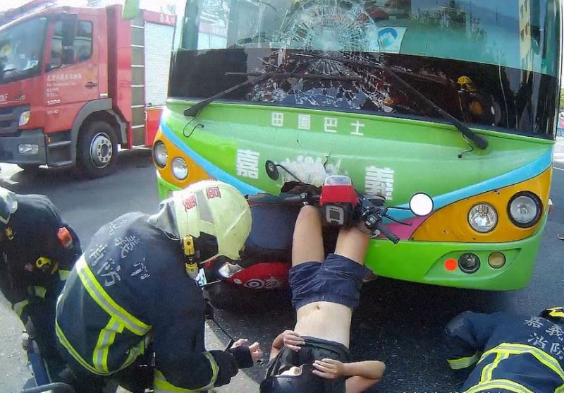 ▲機車與公車對撞車禍,機車頭撞進公車頭內,年輕女駕駛雙脚也卡進公車頭。(圖/嘉義市消防局提供)