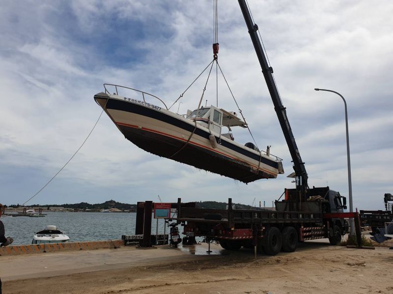 ▲米克拉颱風來襲，漁民僱請吊車將停泊在水頭港區的船隻吊上岸。(圖/記者蔡若喬攝)