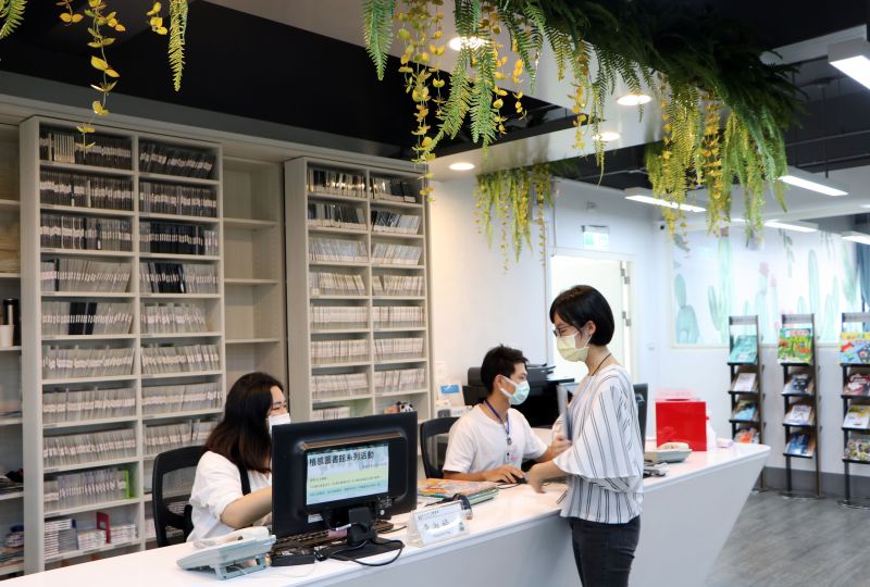 ▲翻修後重新開幕的三重五常分館大變身,不但服務櫃檯垂墜藤蔓,牆柱懸掛著吊盆植物,還有讓人眼睛為之一亮的綠隔牆。(圖/新北市圖書館提供)