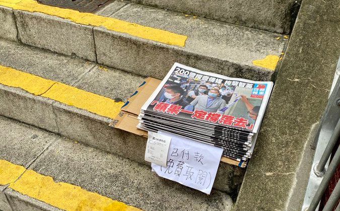 ▲黎智英被捕隔日，香港市民透過購買報紙「稱蘋果」，街上可見到有民眾將多購買的報紙分享給路人。（圖／翻攝自