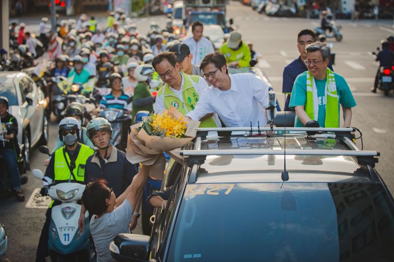 ▲民進黨高雄市長補選候選人陳其邁車隊掃街,民眾獻花。(圖/陳其邁競選總部提供)