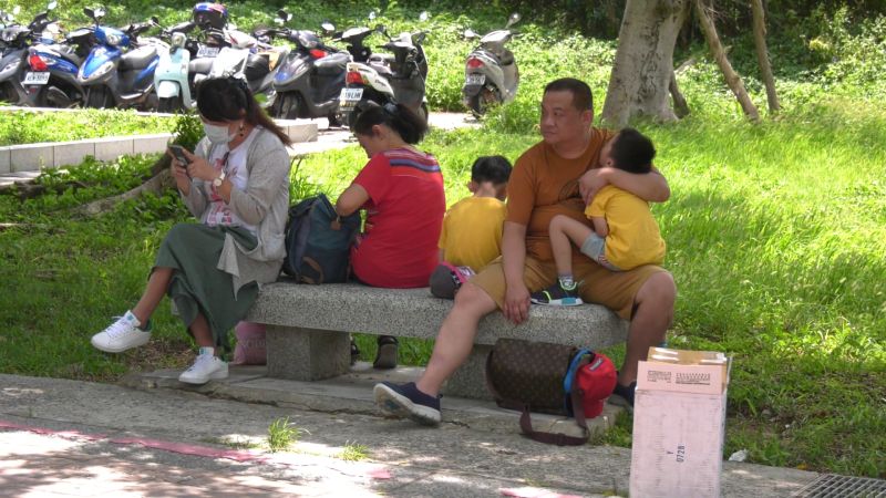 ▲爸爸抱著小朋友在太武山下苦苦等待,一臉無奈。(圖/記者蔡若喬攝)